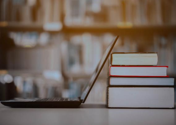 Bookshelves and laptops are placed on the library desk.E-learning class and e-book digital technology