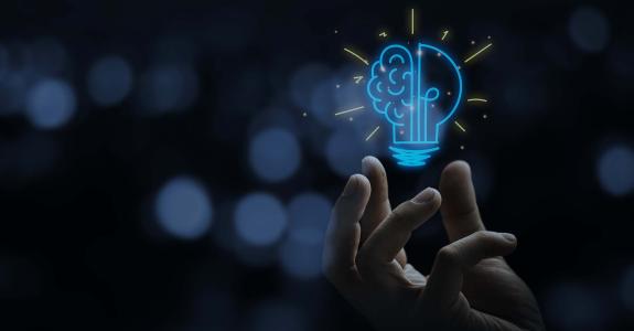 Hand holding drawing virtual lightbulb with brain on bokeh background for creative and smart thinking idea concep