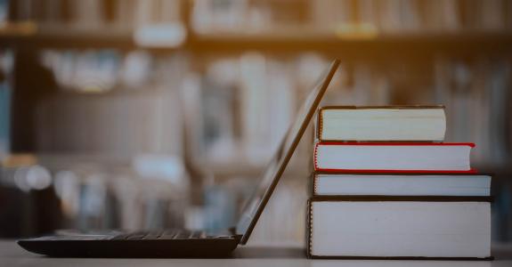 Bookshelves and laptops are placed on the library desk.E-learning class and e-book digital technology